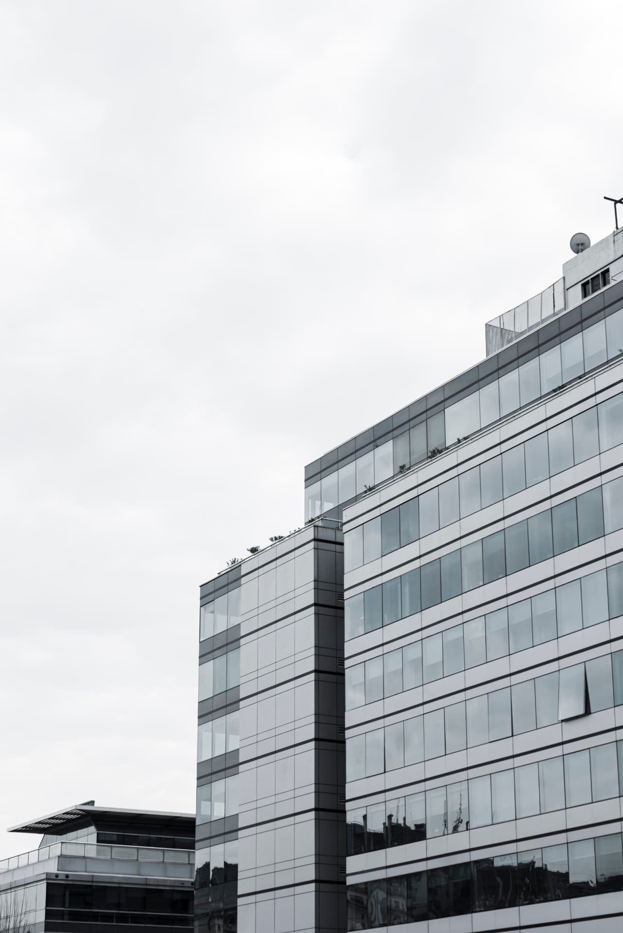 Fachada de edifício corporativo em vidro e aço sob céu claro